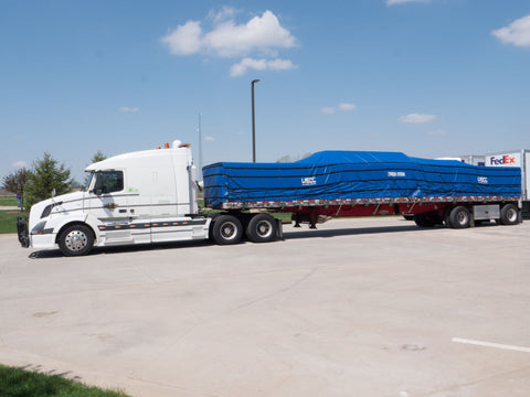 flatbed trailer with tarps and reverse-action ratchet strap tie downs