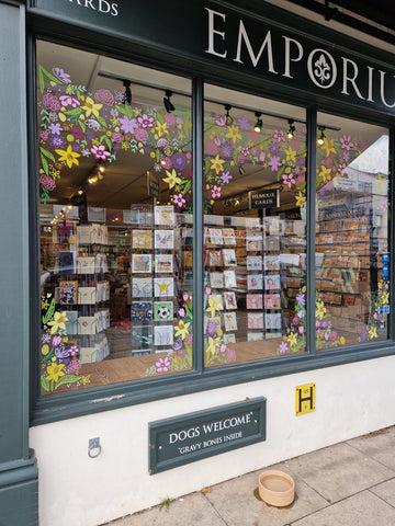 photograph of the Emporium shop window with flowers and foliage painted on to celebrate Spring and Mothering Sunday