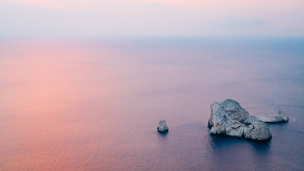 aerial photography of brown rock formation near body of water photo