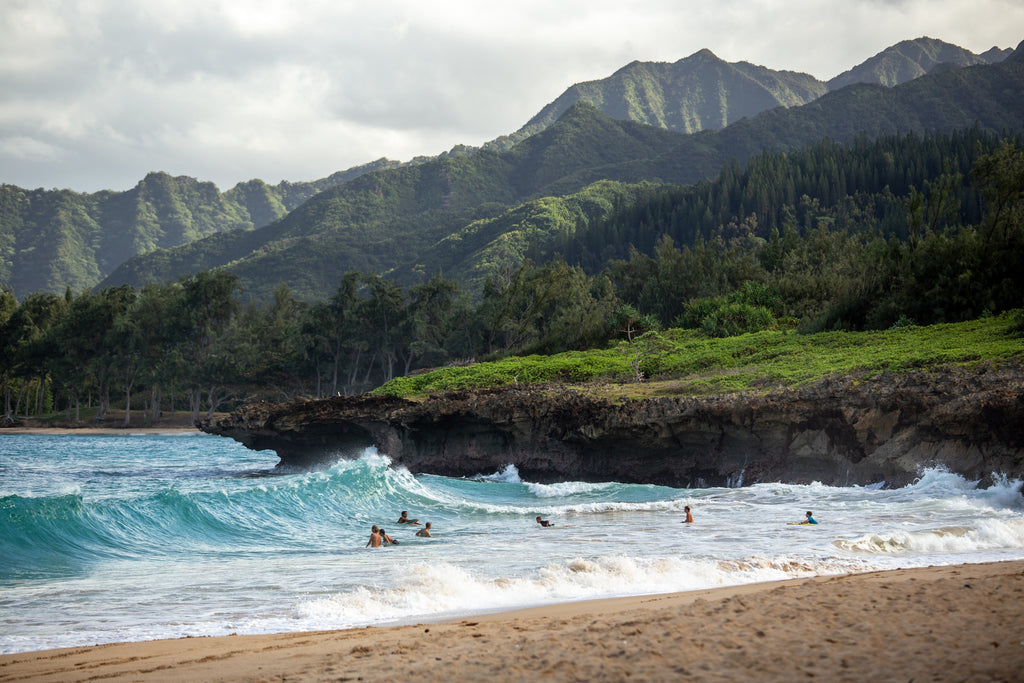 people swimming near shore with waves during daytime photo