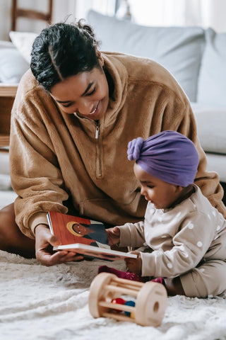 Mother reading to her baby on the floor