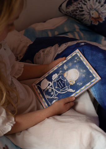 Girl reading Forivor storybook in bed 