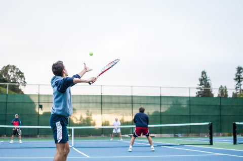 Tennis player serving on tennis court