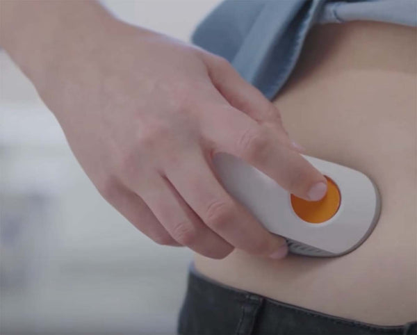 Dexcom ONE CGM system applicator being attached on abdomen.