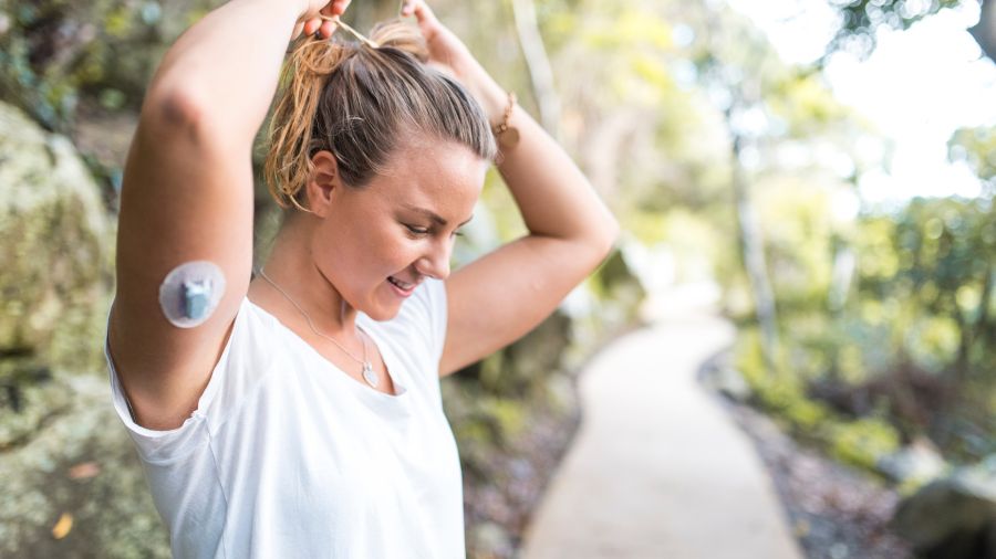 Image from JDRF UK showing female wearing CGM on upper arm.