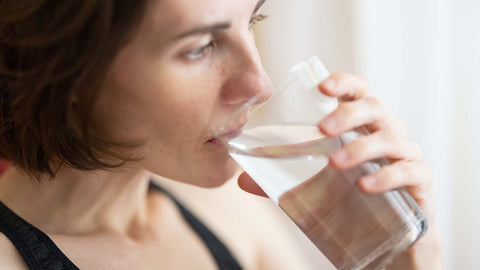 Female drinking glass of water.