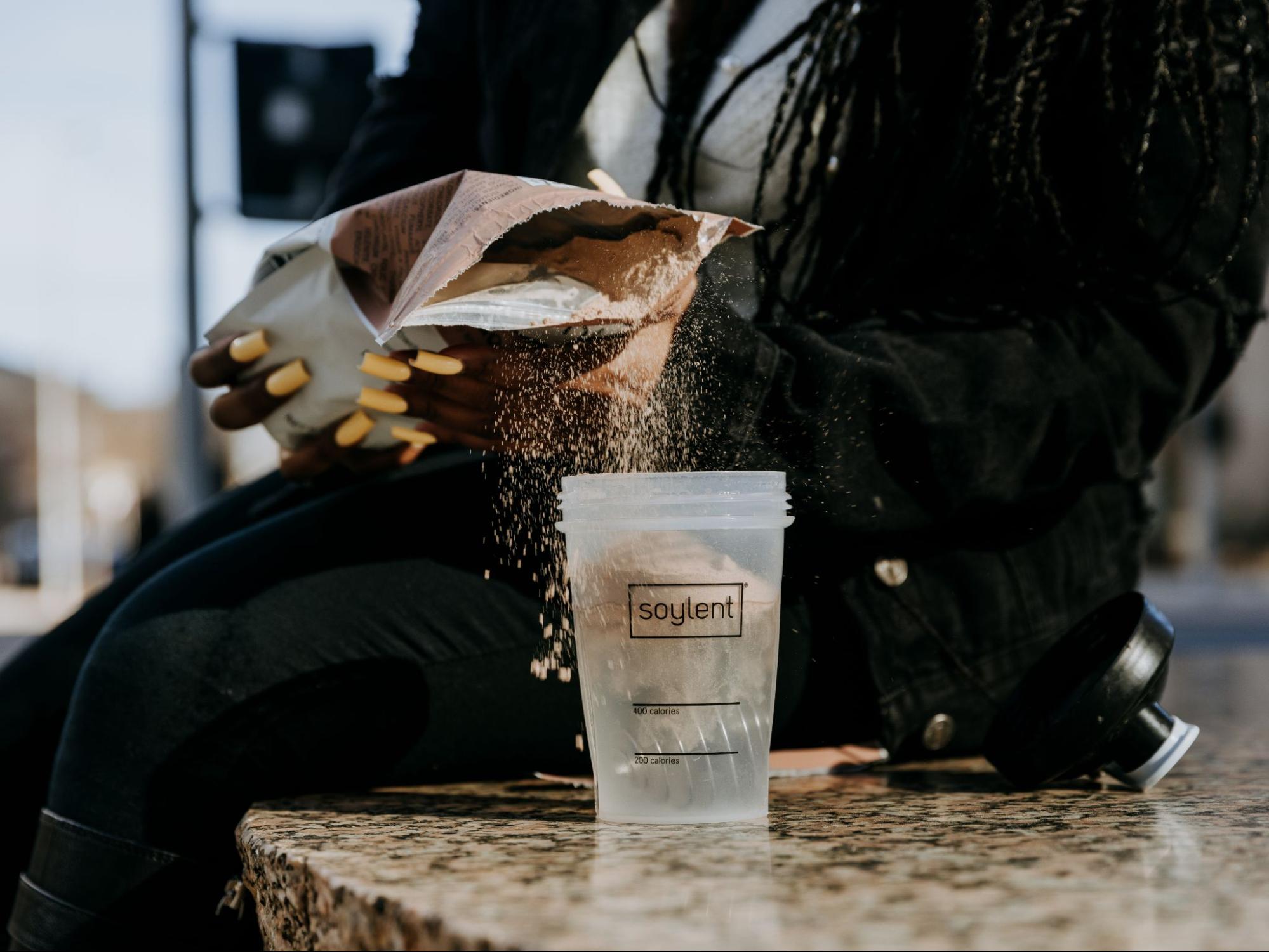 Pouring Soylent Powder into Bottle