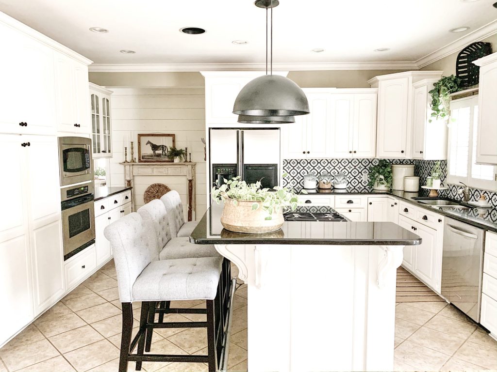 white kitchen reveal with black dome pendants over island.