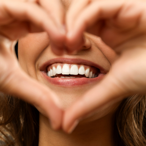 smiling woman making a heart with her hands