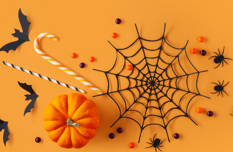 orang background with spider web, halloween candy and spiders