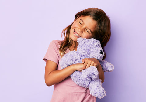 Warmies' Purple Teddy Bear Embraces Joyful Moments.