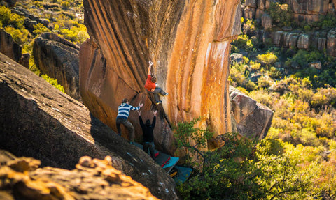 Group of people bouldering outdoors.