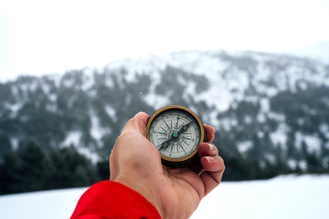 person using a compass in the snow