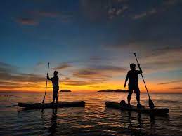 two men on SUP's in sunset