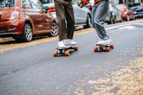 two boys on skateboard on road