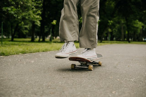 person skating on road with green trees
