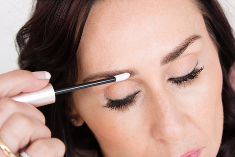 Woman applying eyebrow growth serum