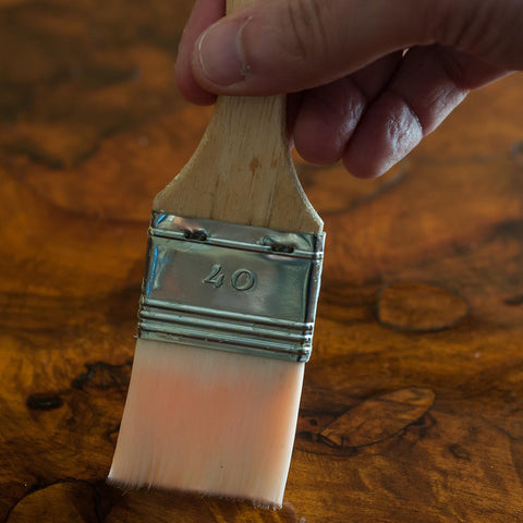 person using a brush on furniture