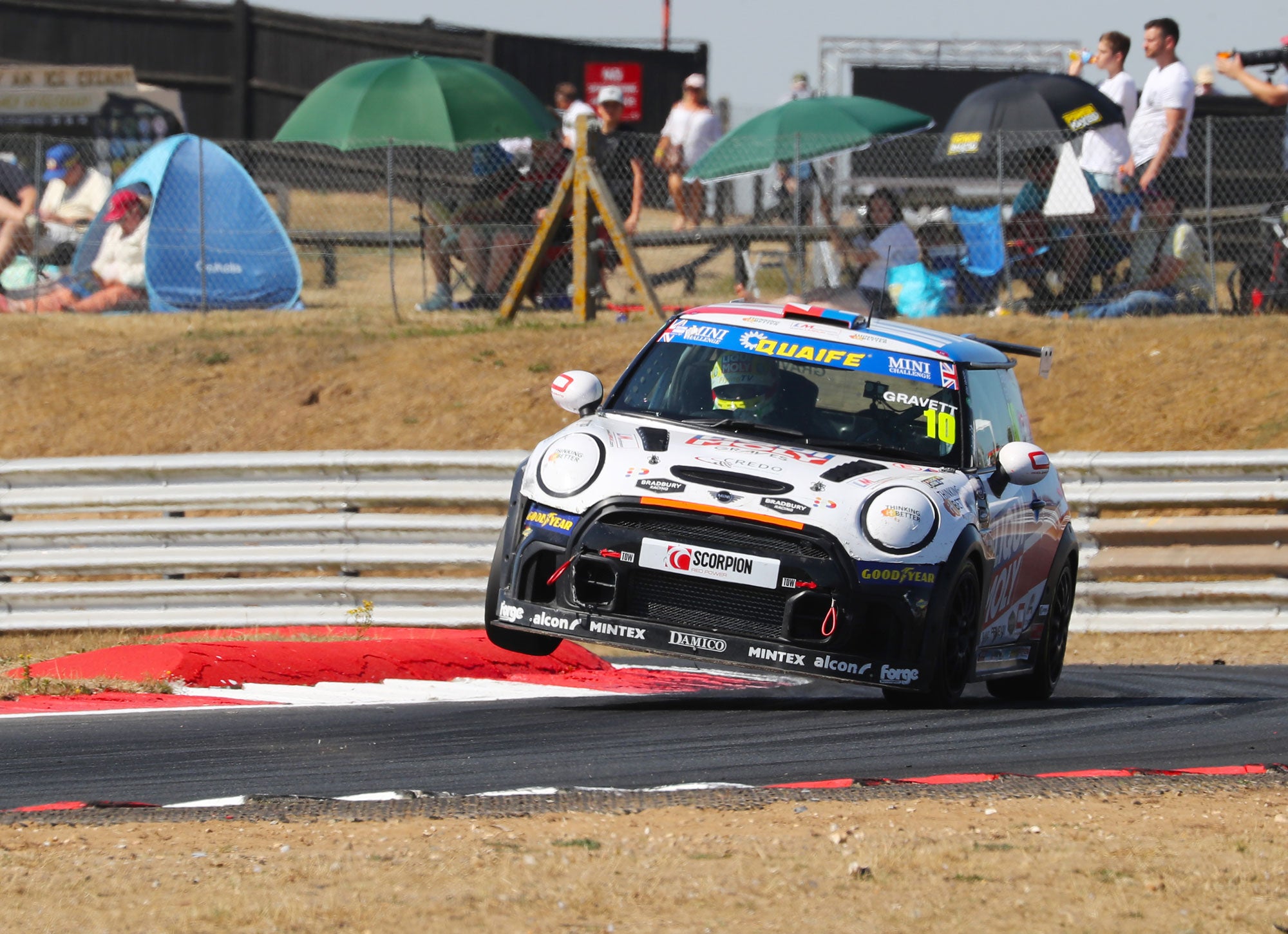 Bradley Gravett son of BTCC British Touring Car Champion Robb Gravett in the MINI Challenge JCW Series at Snetterton in 2022 Bradley In the Air over Curb Cooper Racing Driver LIQUI MOLY LM Performance Thinking it Better Elite Vehicle