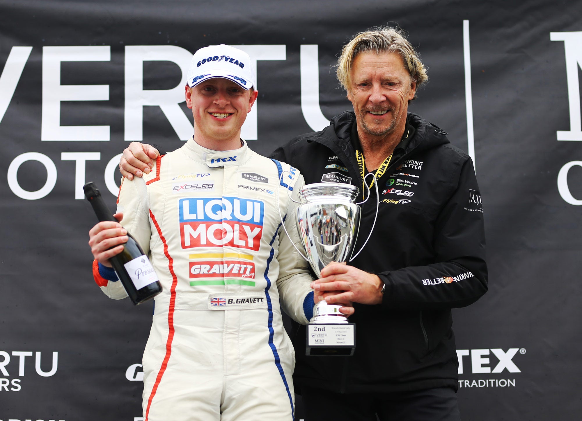 Bradley Gravett standing on the podium with father and ex BTCC champion Robb Gravett at Brands Hatch 2023