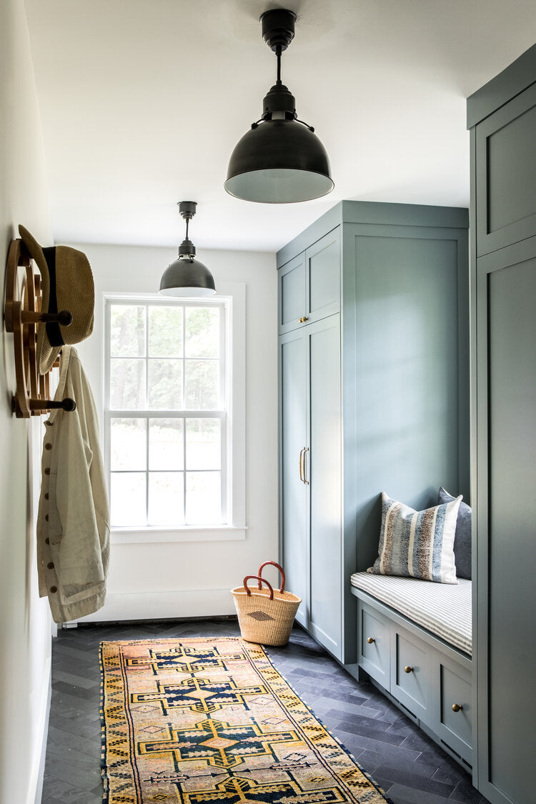 mudroom with green cabinets and slate floor