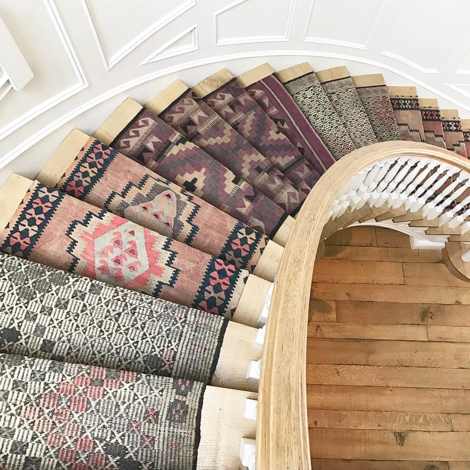 escaleras con corredor hecho con alfombras antiguas
