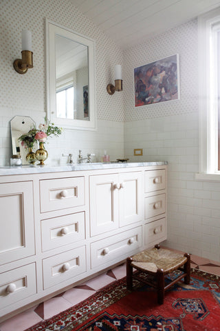 bathroom with pink vanity and vintage rug