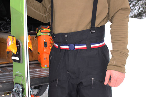 Ben Goertzen holding skis, while wearing Jelt's USA belt