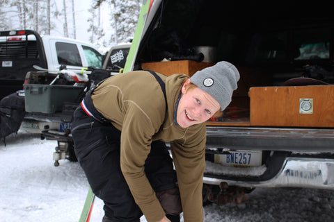 Ben Goertzen putting on ski boots, while wearing Jelt's USA belt