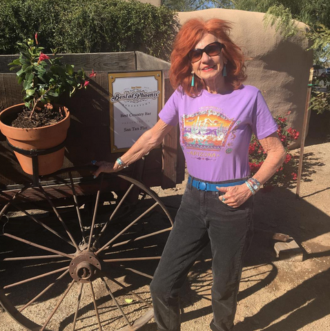 Woman wearing a Jelt elastic Jelt belt while standing in front of flower planter