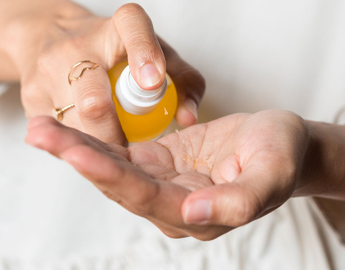 Person pouring oil cleanser on their hand