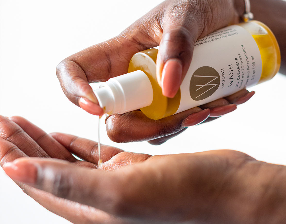 Person pouring oil cleanser on their hand