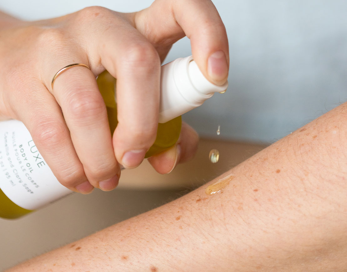 Person applying Luxe Body Oil to their arm