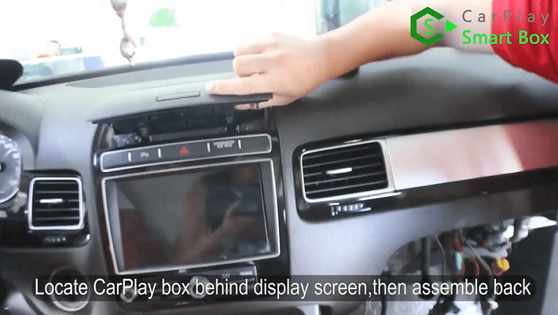 16.Individuare la scatola CarPlay dietro lo schermo del display, quindi rimontarla.