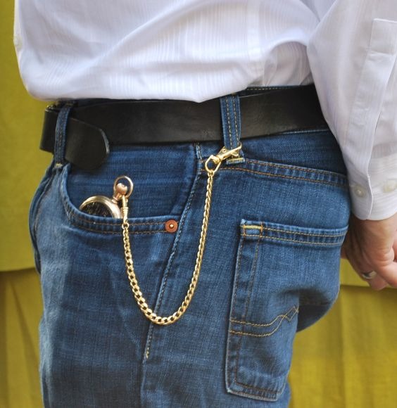 Homme portant une jean et chemise blanche avec une montre à gousset dans la poche du pantalon, avec une chaine de montre simple