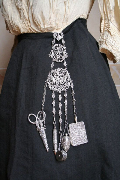 Zoom sur une chatelaine par dessus une jupe noire 