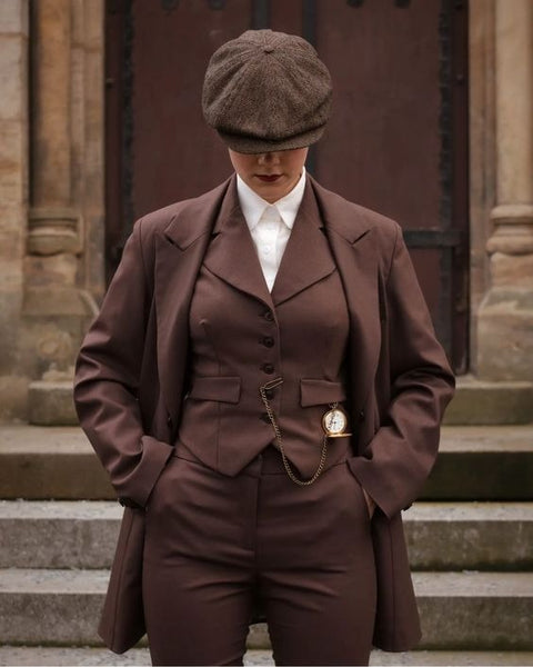Femme en costume marron  et casquette , montre à gousset sur le gilet