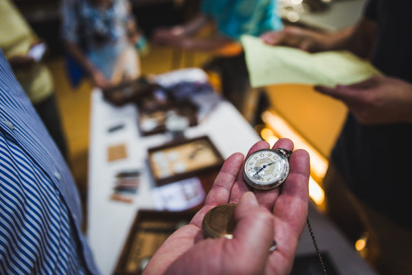 Montre à gousset dans la main d'un homme chez un horloger