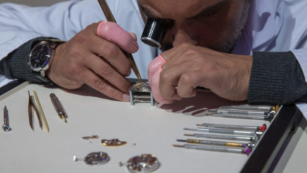 Horloger avec une pince réparant une montre