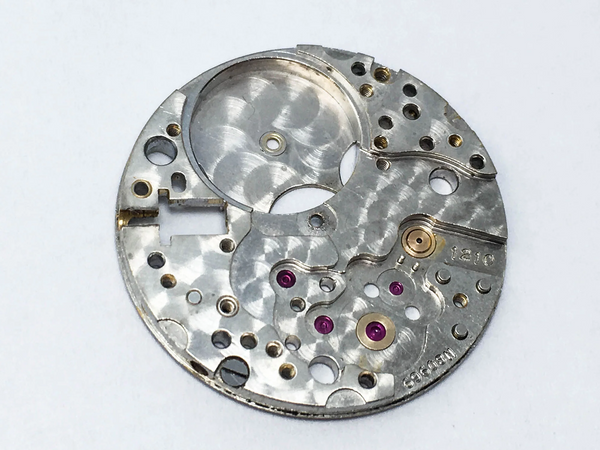 La platine d'une montre, plaque métallique plate et ronde servant de support pour les pièces de la montre 
