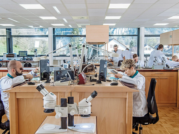 Vaucher, atelier de fabrication de pièces horlogères avec plusieurs personnes y travaillant