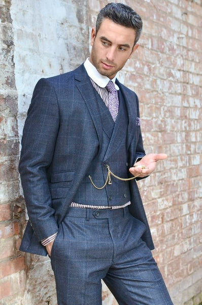 Homme en costume 3 pièces bleu avec une montre à gousset dans la main