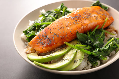 salmon with spinach and avocado on a plate