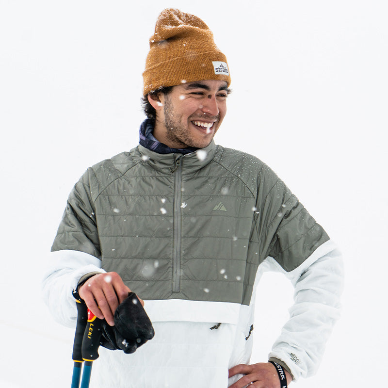 latino skier smiling in the snow in the ice aero pullover insulator