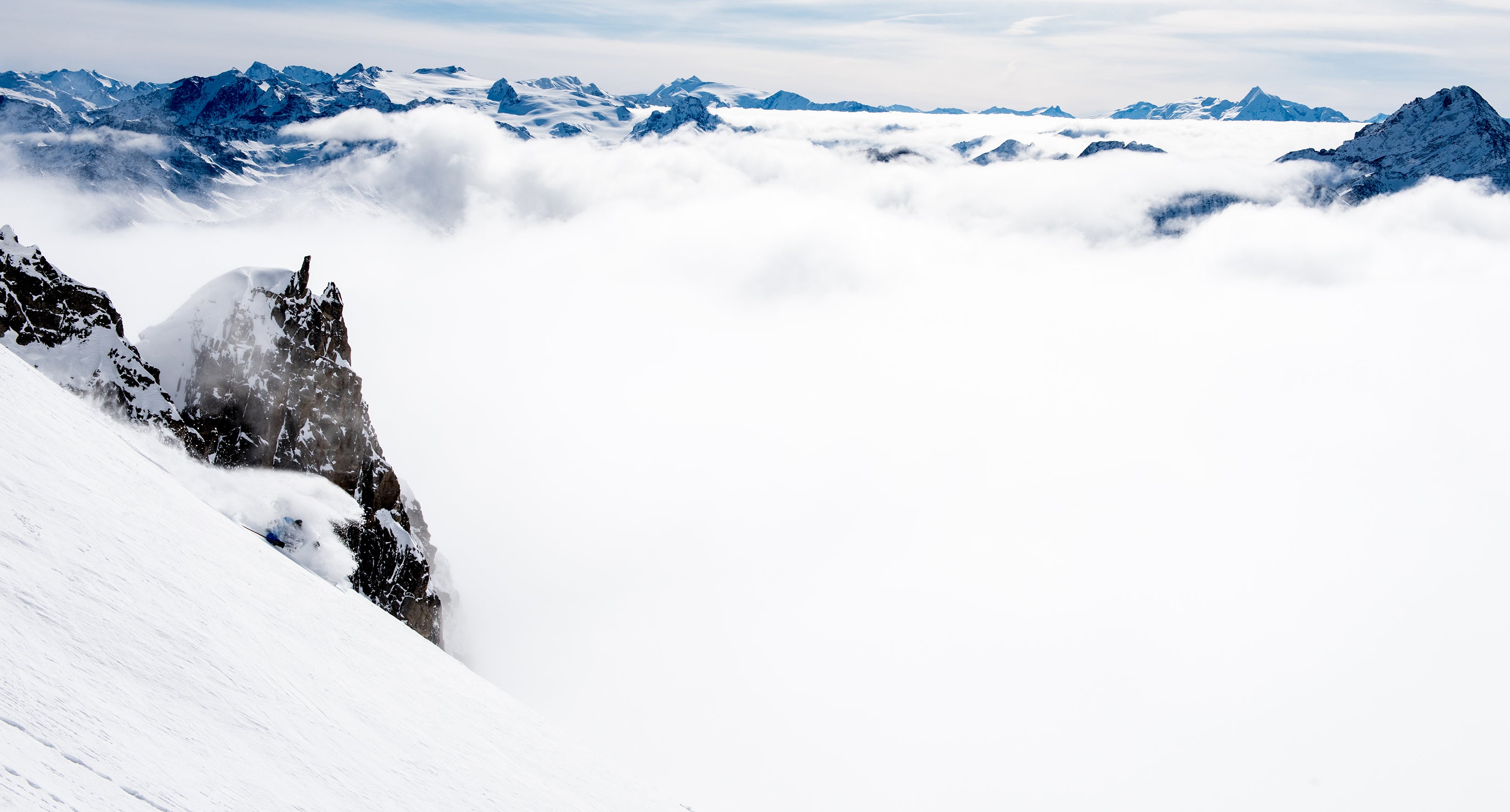 Skier turning above the cloud-covered Italian valley