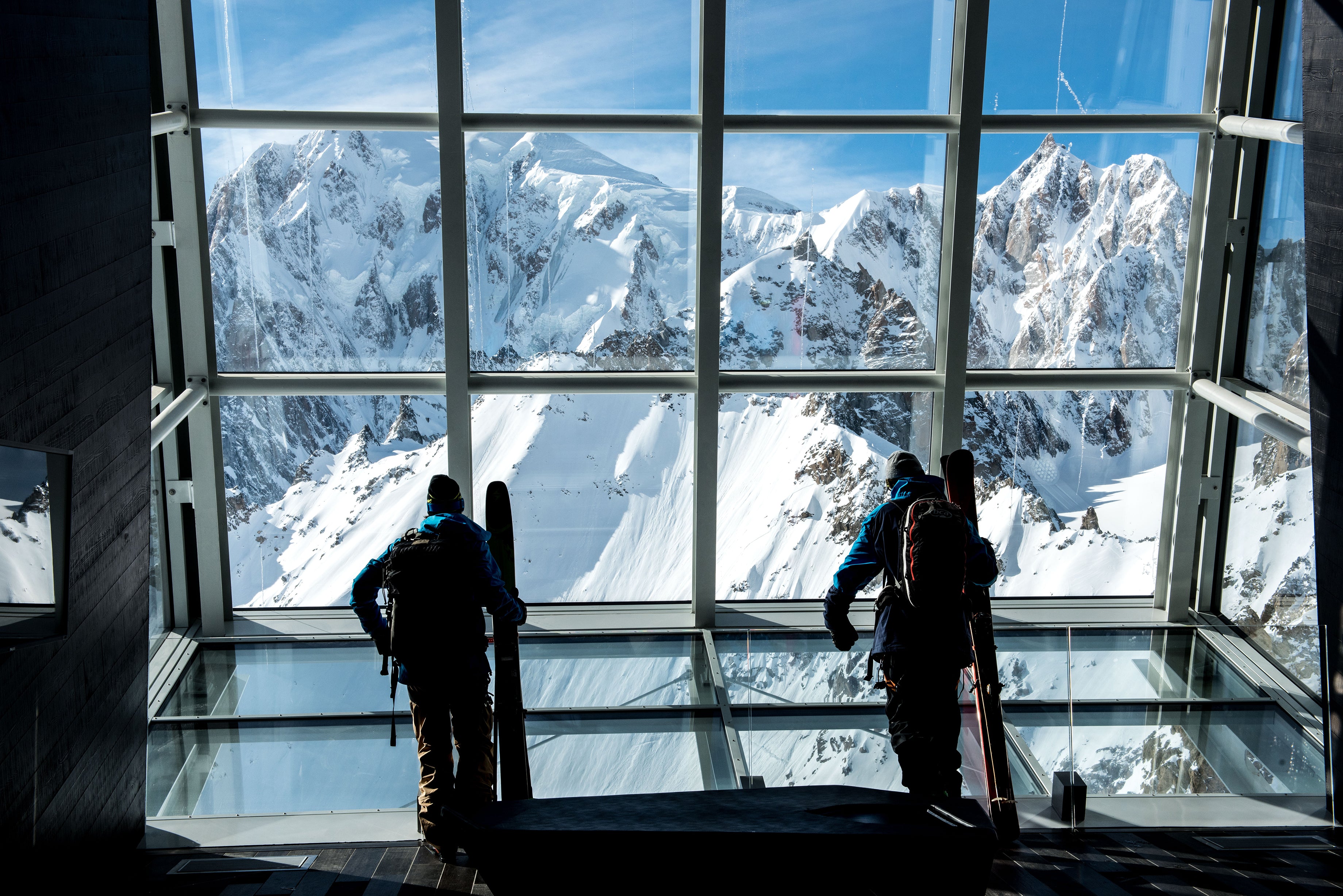 Skiers look out the tram station windows