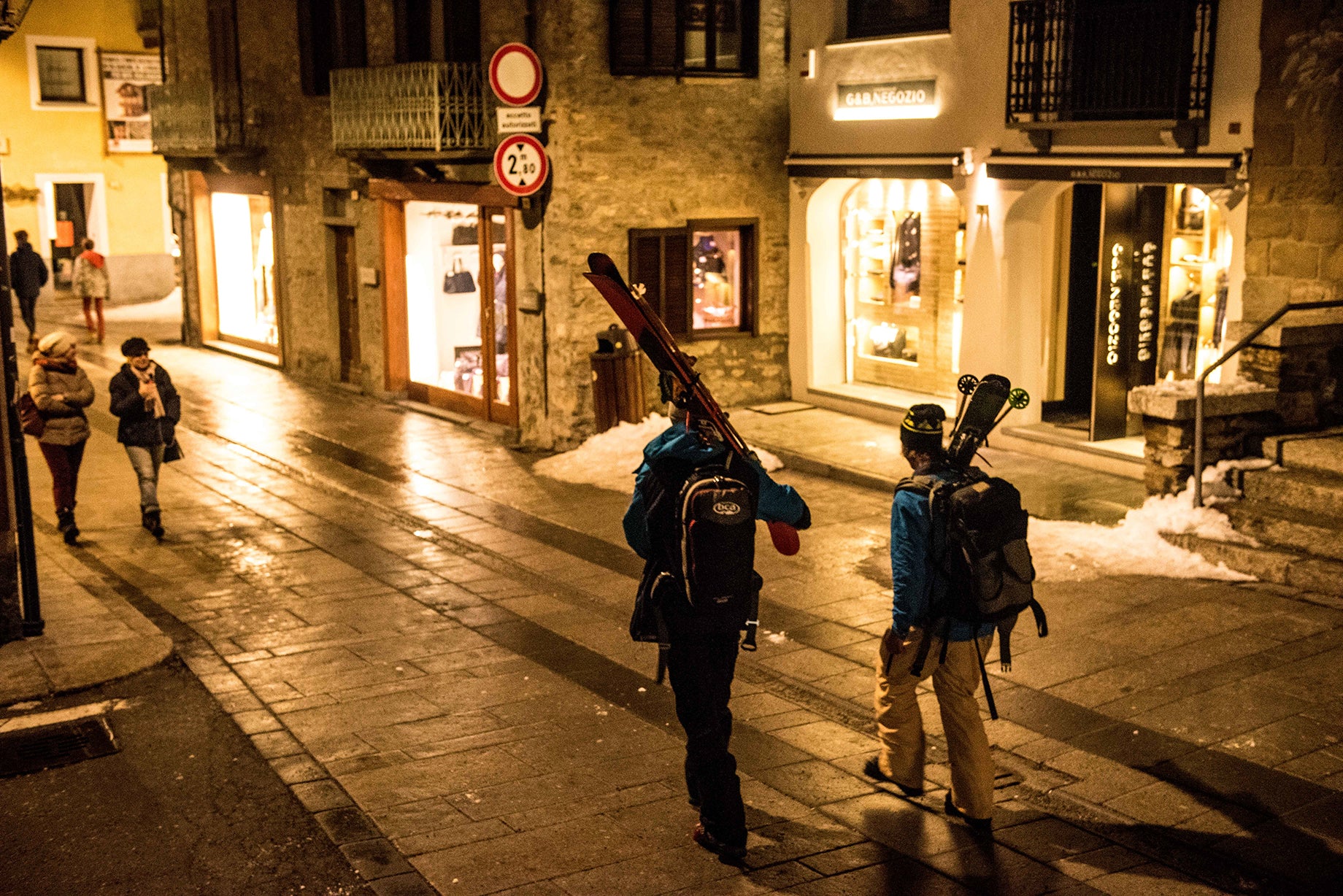 Skiers walking through town at night