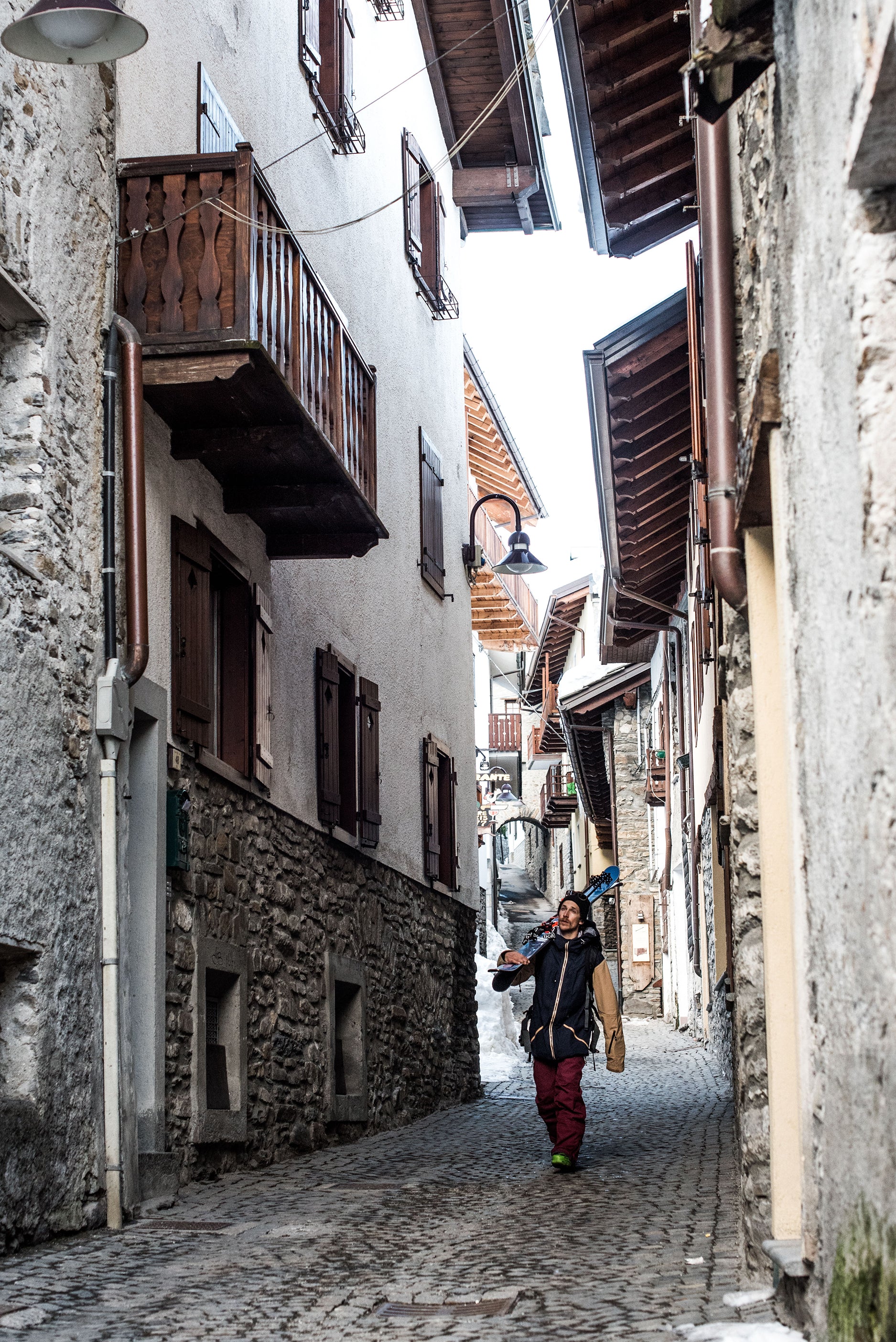 Skier walking over cobbled European streets