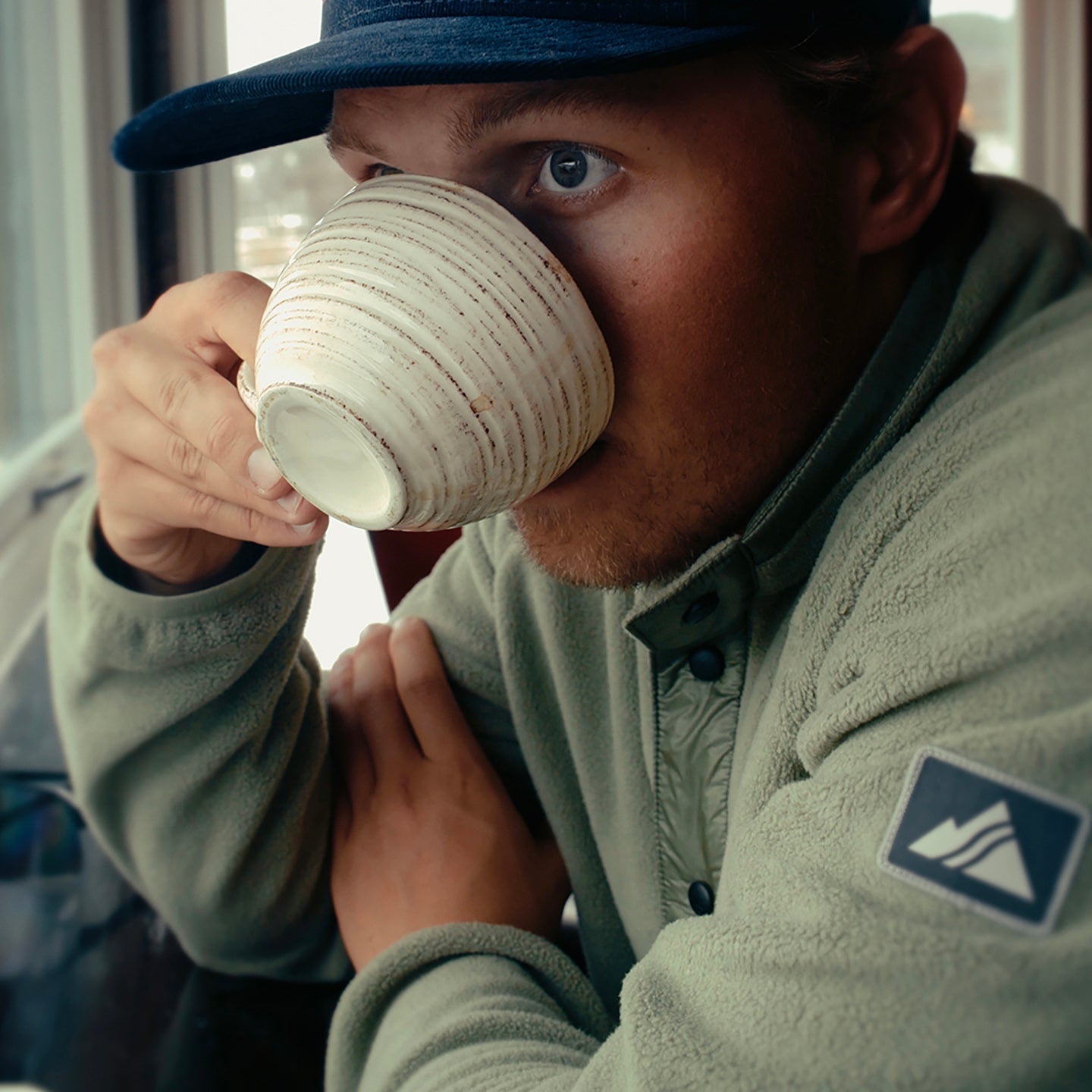 hunter hill drinking coffee in the ajax snap fleece