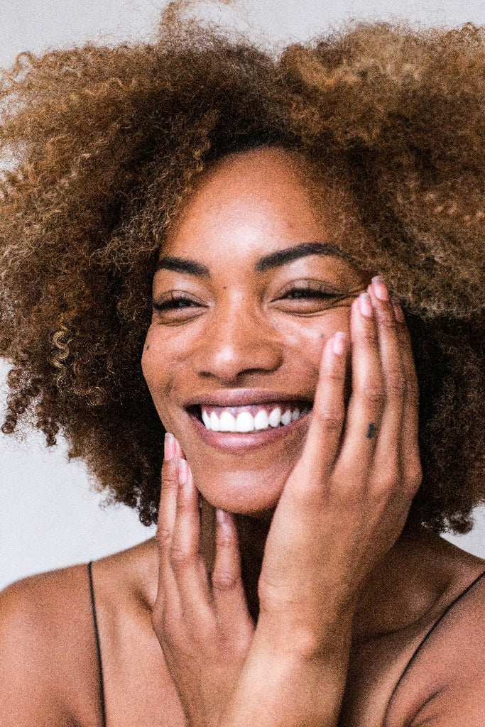 smiling woman touches face